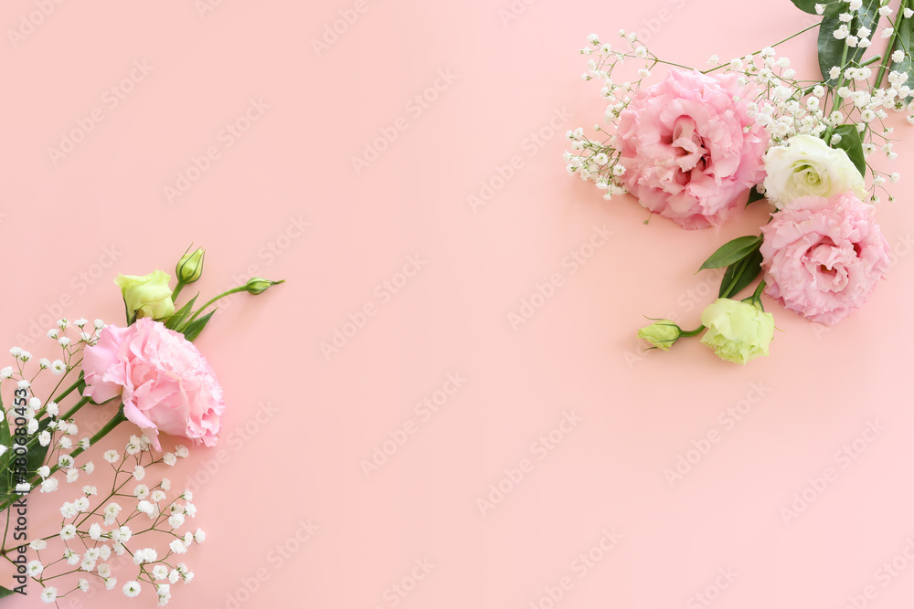 Top view image of delicate pink lisianthus flowers over pastel background