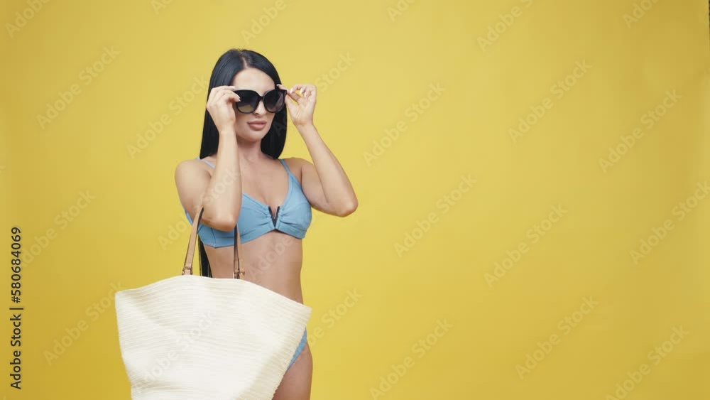 Happy youth beautiful Asia woman takes out glasses from her bag on empty space yellow background Happy youth beautiful Asia woman takes out glasses from her bag on empty space yellow background