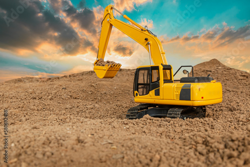 Crawler excavator is digging soil in the construction site with sunset backgrounds.