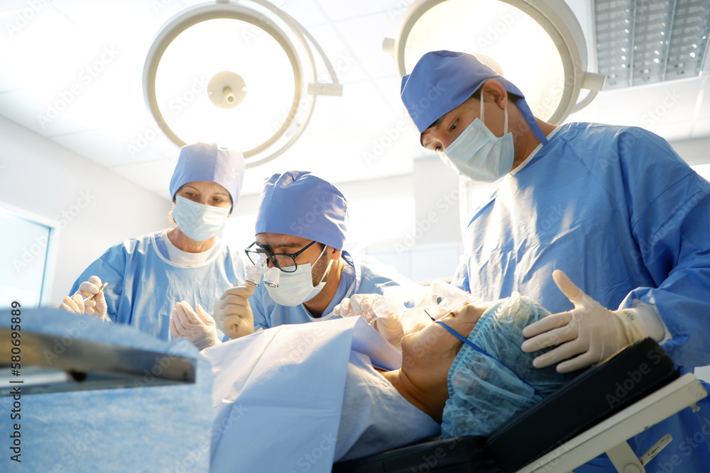 Team of doctors and nurses perform surgery on a patient in the emergency room. medical concept. Team of doctors and nurses perform surgery on a patient in the emergency room. medical concept.