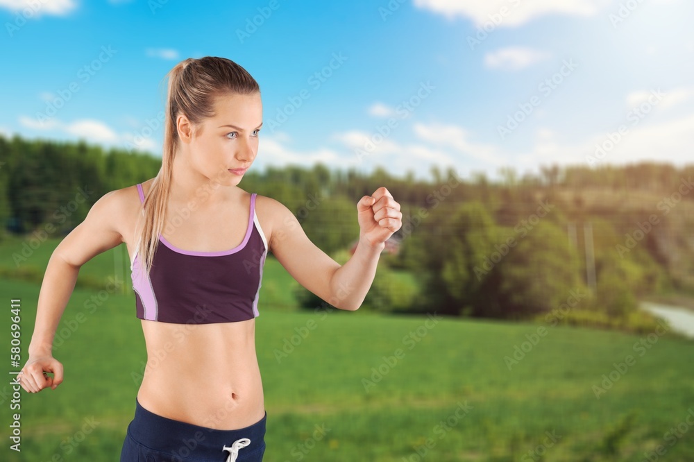 Happy slim sporty woman jogging in the park