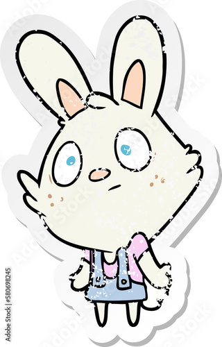 distressed sticker of a cartoon rabbit shrugging shoulders