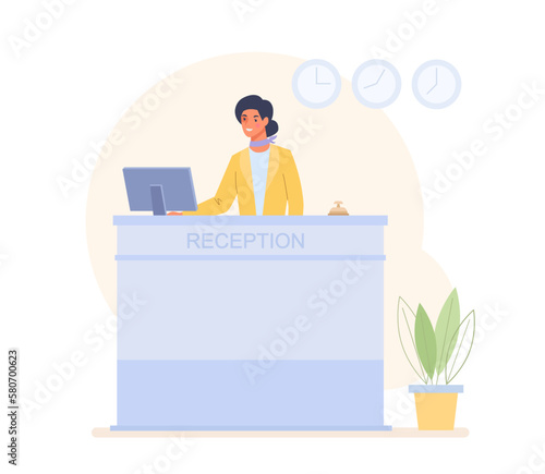 Woman stands at the hotel reception desk and works at her computer