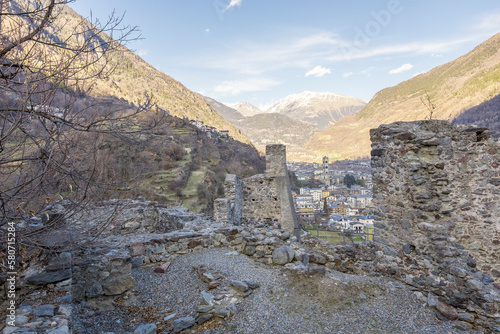 Valtellina, Italy - March 12, 2023: street view of the ancient walls surrounding Old Castle in Grosio, a fort in ruins. No people are visible, background is the mountains of Valtellina. photo