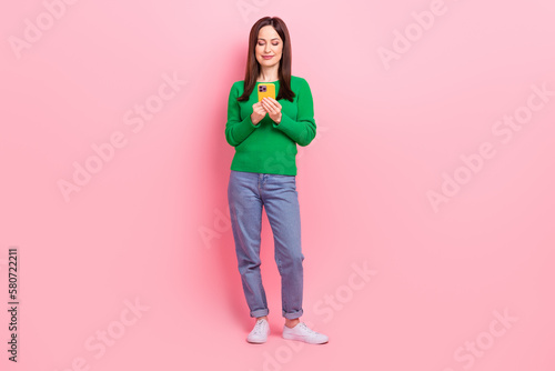 Full size portrait of pretty positive girl hold use telephone write blog post isolated on pink color background