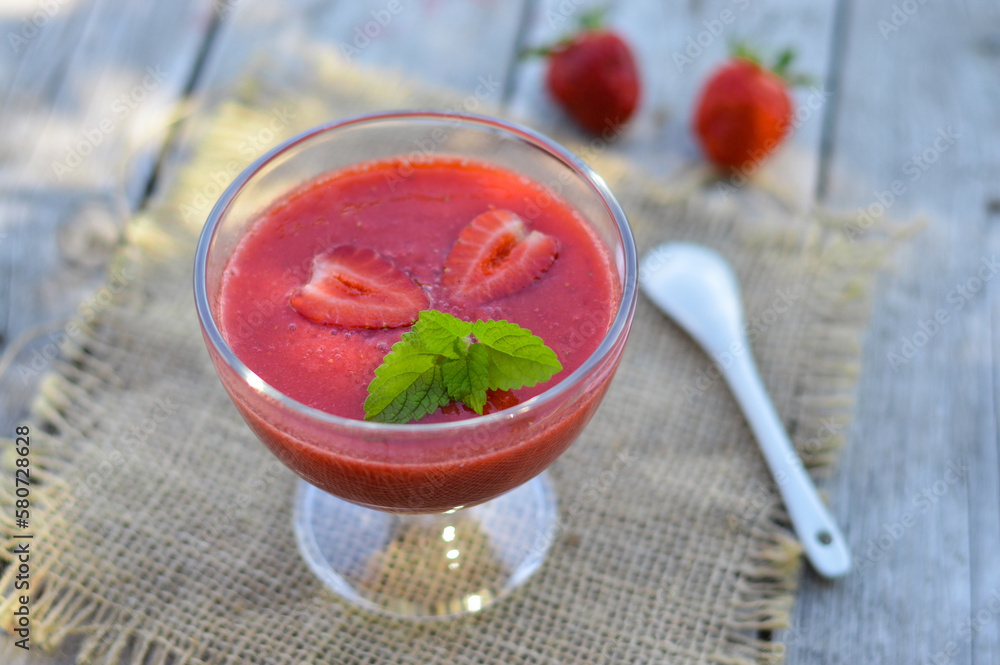 Strawberry smoothie in a glass decorated with mint leaves on rustic background, fresh fruit juice is red, detox food, diet and healthy breakfast, top view Strawberry smoothie in a glass decorated with mint leaves on rustic background, fresh fruit juice is red, detox food, diet and healthy breakfast, top view
