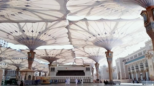 Medina, Saudi Arabia, 2022 - Umbrella construction on the square of Al-Masjid An-Nabawi or Prophet Muhammed Mosque are protecting people from sun at the daytime and works as lights at night photo