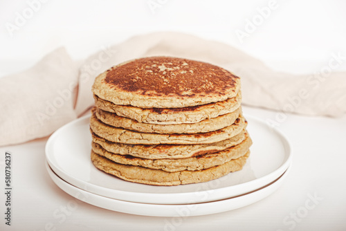 Freshly baked farinata pancakes made from chickpea flour stacked on white plate. Healthy food. Typical italian dish.