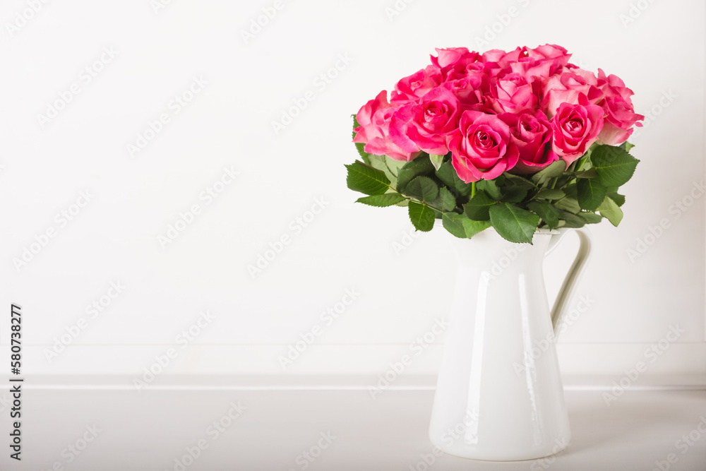 Obraz premium Beautiful bunch of fresh pink roses in full bloom against white background. Bouquet of flowers. Copy space for text. Valentine's day or Mother's day card.