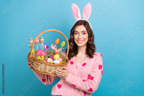 Canvas Print Photo of positive cute lady dressed pink cardigan rising easter snacks basket is