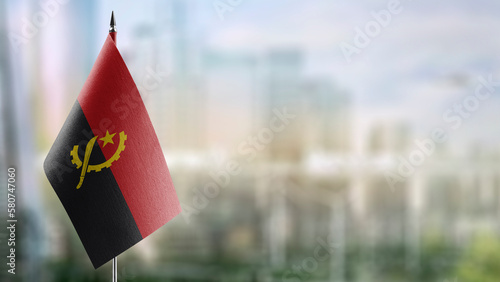 A small Angola flag on an abstract blurry background