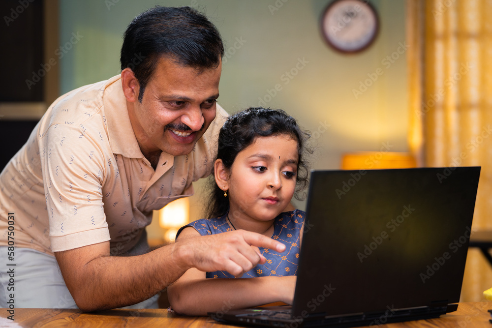 Father teaching or explaining from laptop to kid at home - concept of home schooling, caring and childhood growth or development. Father teaching or explaining from laptop to kid at home - concept of home schooling, caring and childhood growth or development.