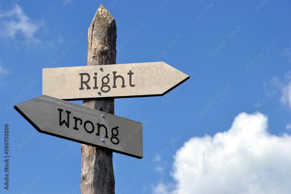 Right or wrong - wooden signpost with two arrows, sky with clouds Right or wrong - wooden signpost with two arrows, sky with clouds