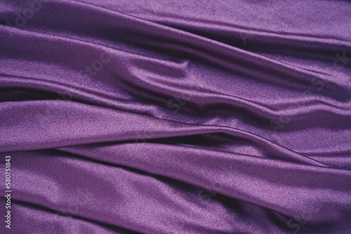 Velour fabric, similar to silk. Textiles in a folds and beautiful waves. Purple, pink, magenta shades on the drapery. Sewing material for evening dresses, furniture upholstery, curtains and interior.