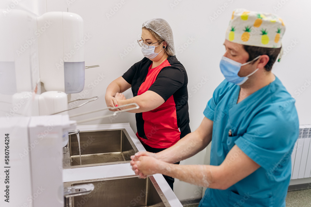 Surgical team members scrubbing arms and hands before surgical