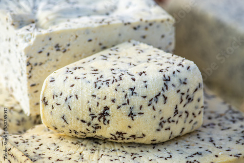 Homemade bio natural cheese with cumin seeds in a street food market, close up