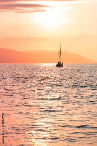 Fototapeta Naklejka Na Ścianę i Meble -  Silhouettes of sail and fishing boats in the ocean marina at sunset hour, selective focus, beautiful colorful orange sky. Water sports, travel, tourism concept.