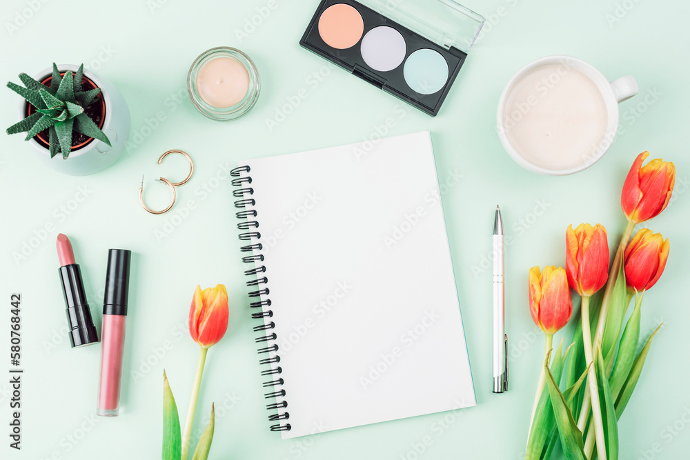 Blank notepad, cup of coffee, make up cosmetics and bouquet of orange tulips on light green background, top view. Women's day or Mother's day concept. Creative flat lay, mockup Blank notepad, cup of coffee, make up cosmetics and bouquet of orange tulips on light green background, top view. Women's day or Mother's day concept. Creative flat lay, mockup