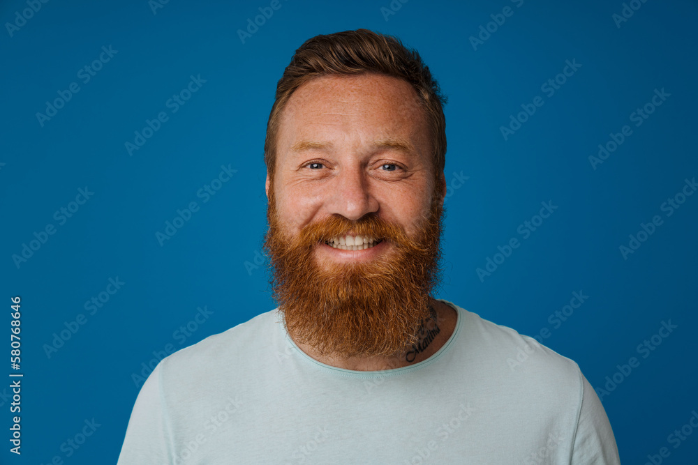 Obraz premium Portrait of adult bearded tattooed handsome stylish smiling man