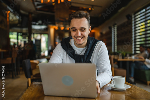 one man work on the computer laptop while sit at cafe or restaurant