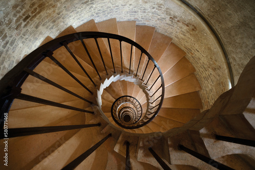 Ancient castle tower interior with spiral staircase leading down