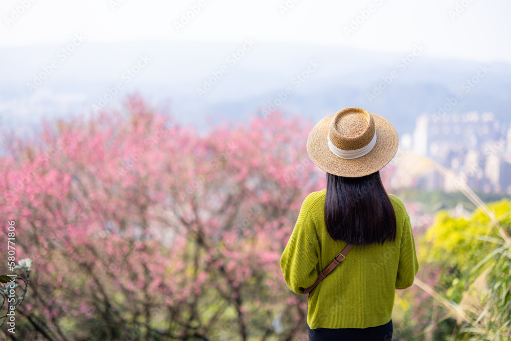 Woman look at the sakura tree on mountain