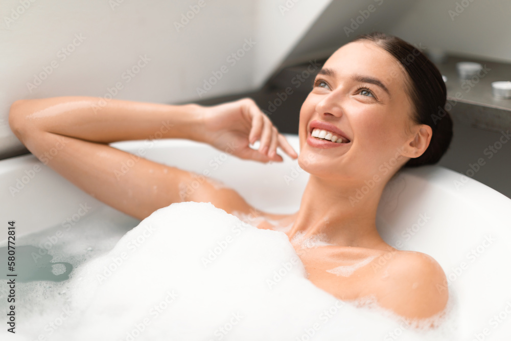 Attractive Female Taking Bath With Foam In Modern Bathroom