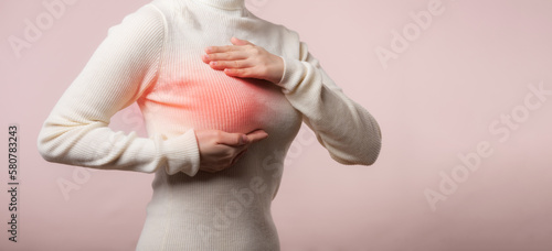 Картината върху платно Woman hands checking lumps on her breast for signs of breast cancer on pink background