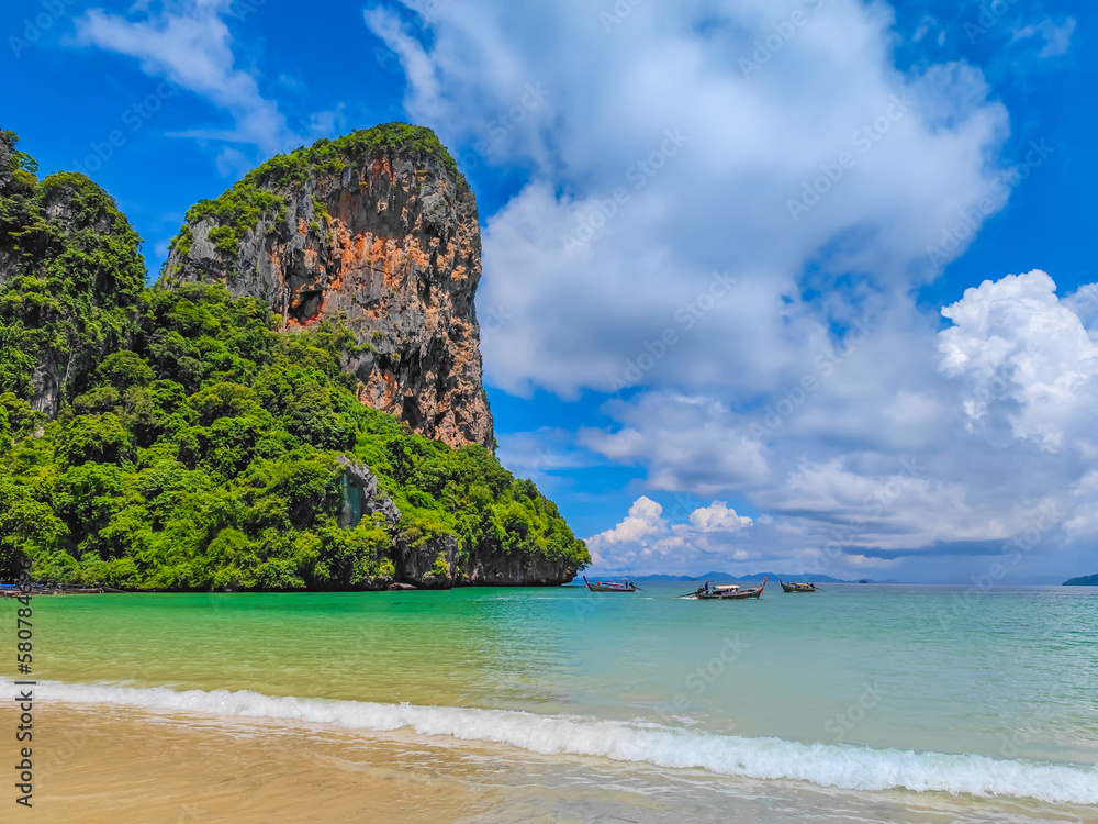 Railay west beach in Krabi district Thailand. Paradise beach with golden sand and green mountains around