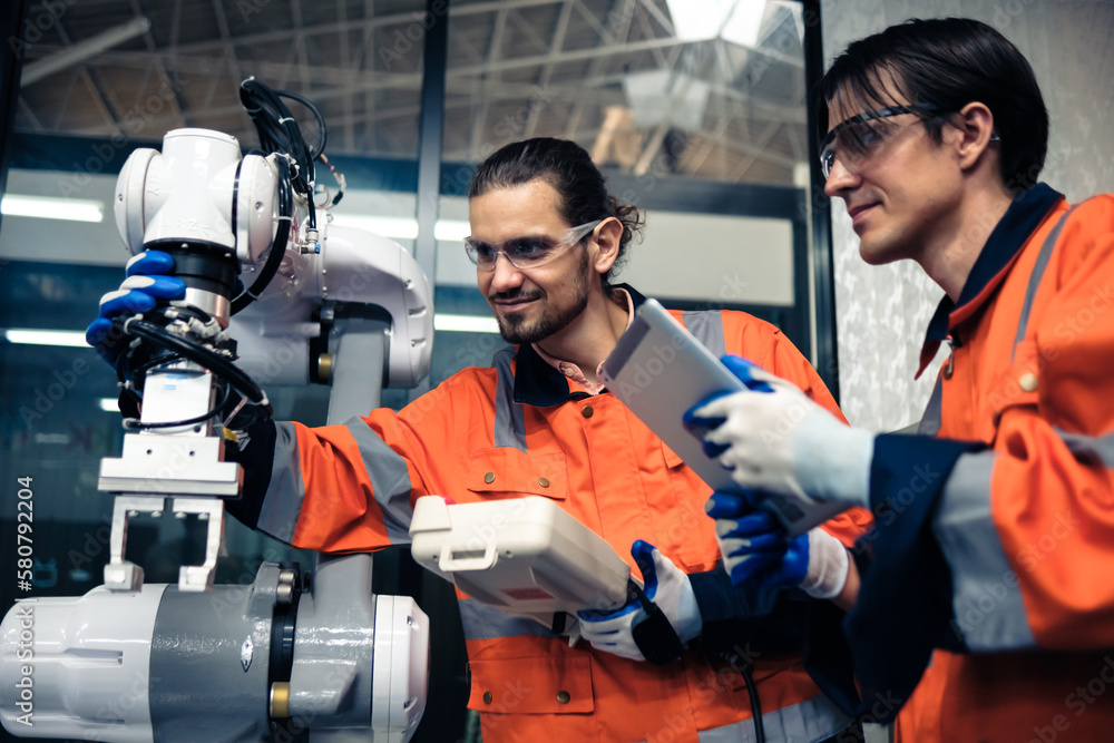 Multiracial tachnicial engineer training with robot arm Multiracial tachnicial engineer training with robot arm