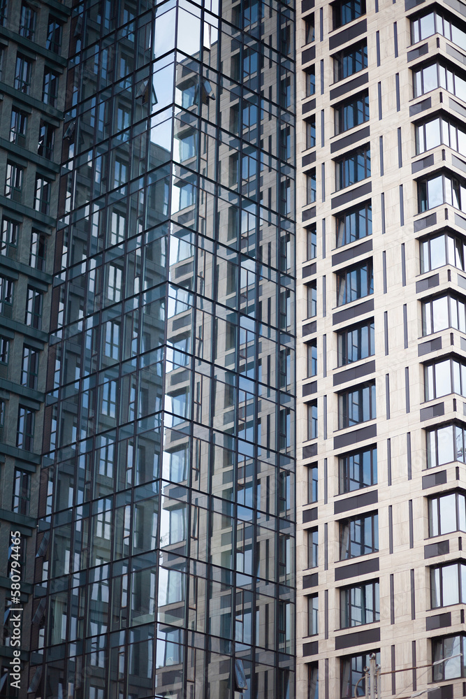 Fototapeta premium Modern skyscrapers with reflection in windows, background with blue textures