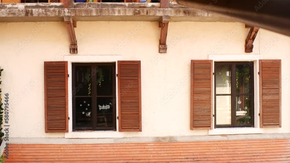 Windows with wooden shutters on the wall of the house Windows with wooden shutters on the wall of the house