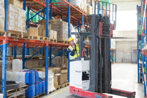 Male employee using a radio in the warehouse.