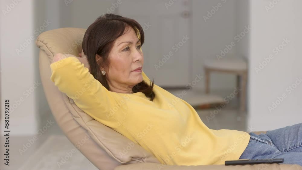 Attractive stylish woman relaxing in comfortable reclining chair at home eyes closed Attractive stylish woman relaxing in comfortable reclining chair at home eyes closed