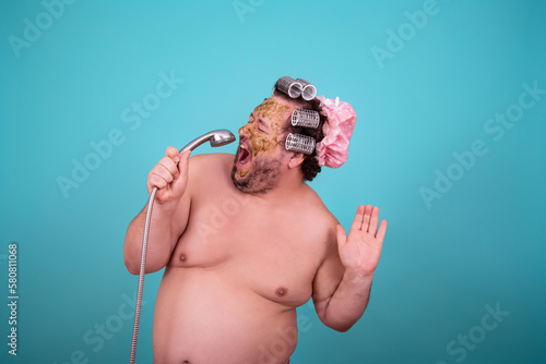 Beauty and skin care. Funny fat man washes in the shower in a cosmetic mask.