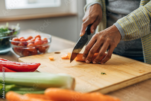 Close up view of vegetables on a table, cutting carrots on a chopping board
