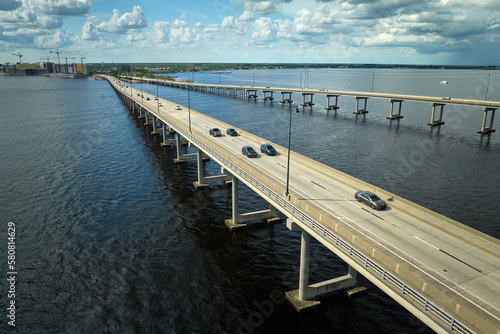 Barron Collier Bridge and Gilchrist Bridge in Florida with moving traffic. Transportation infrastructure in Charlotte County connecting Punta Gorda and Port Charlotte over Peace River photo