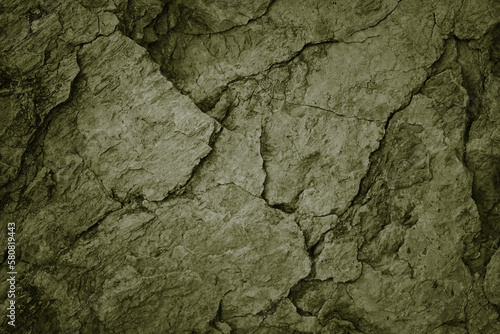 Olive green grunge background. Cracked rough stone surface. Close-up. Broken, crumbled.