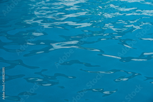 Ripped water in swimming pool. Surface of blue swimming pool, background of water.