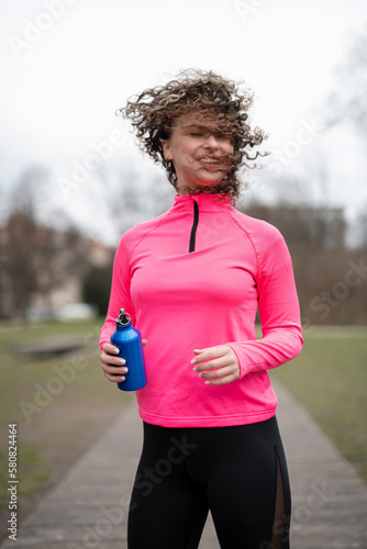 woman drinking water after training