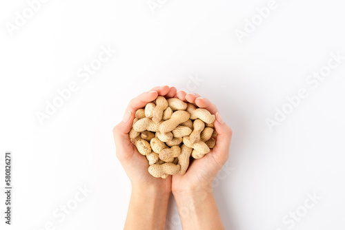 Overhead shot of woman’s hands holding peanuts isolated on white background