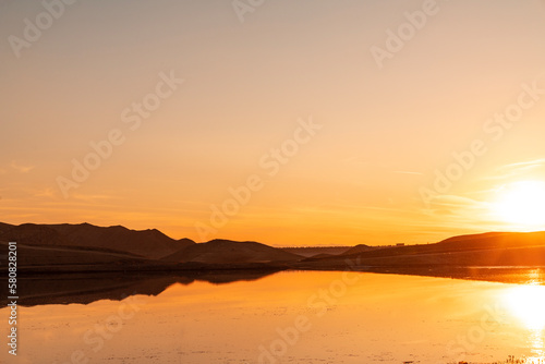 Beautiful sunset over the mountains and lake. Panoramic sunset landscape.
