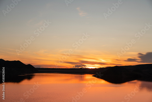Beautiful sunset over the lake with reflection . Panoramic sunset landscape.