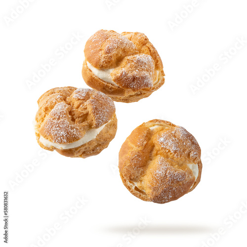 Foto Cream puffs, pastry from choux covered sugar powder closeup falling flying isola