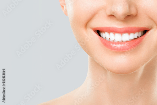 Perfect white teeth smile of a young woman. The result of the teeth whitening procedure. The image symbolizes oral care dentistry  Closeup on a white background.