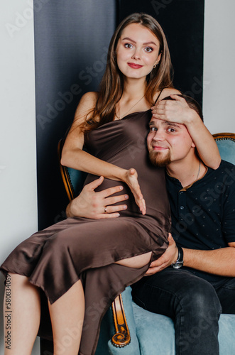a pregnant woman and a man are sitting in a chair