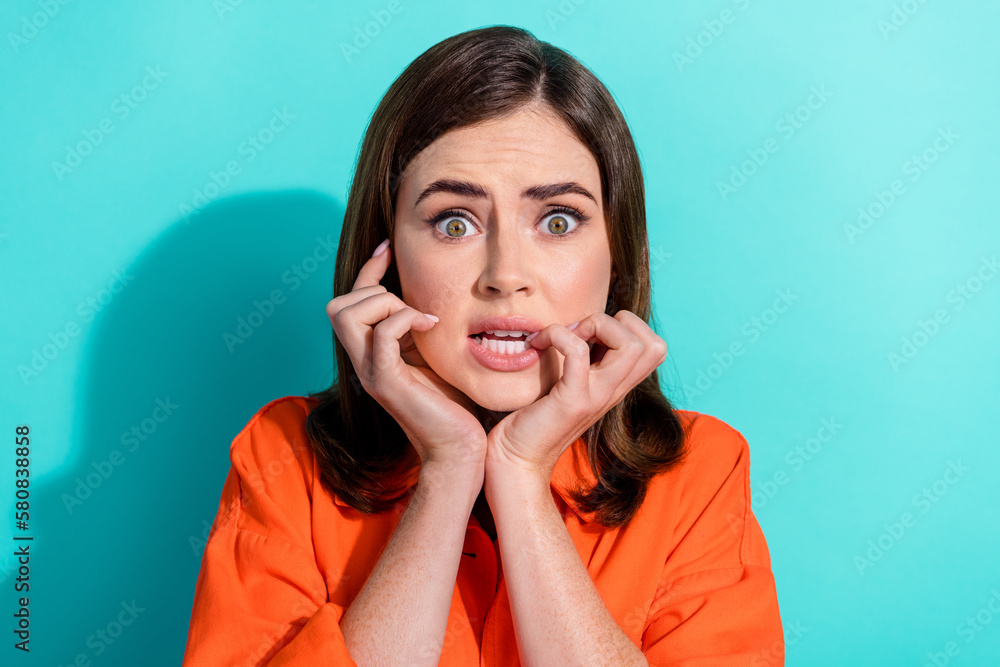 Photo of anxious embarrassed lady wear stylish clothes bite fingernails watching horror film isolated on cyan color background - obrazy, fototapety, plakaty 