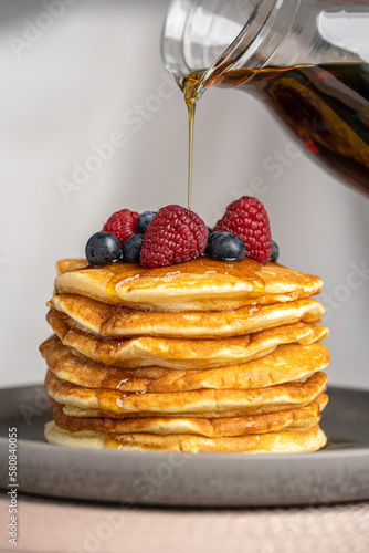 Pancakes with berries and maple syrup stock photo
