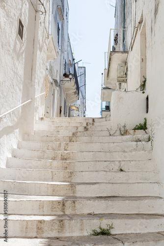 Fototapeta Naklejka Na Ścianę i Meble -  A beautiful view of the whitewashed street staircase in the city of Ostuni.