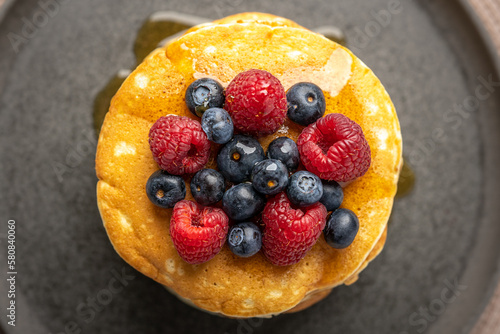 Pancakes with berries and maple syrup stock photo